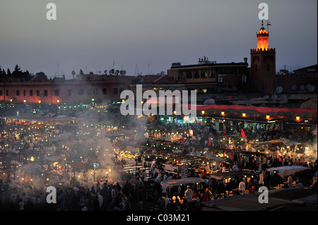 Evening at the Djemaa el Fna market square, literally meaning Assembly of the Dead, with smoke from the many food stalls, behind Stock Photo