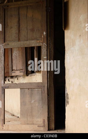 A broken wooden classroom door is left open at the end of the day at a rundown primary school in communist Laos. Stock Photo