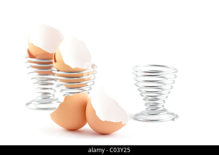 Empty egg shells and stainless steel egg cups isolated on a white background. Stock Photo
