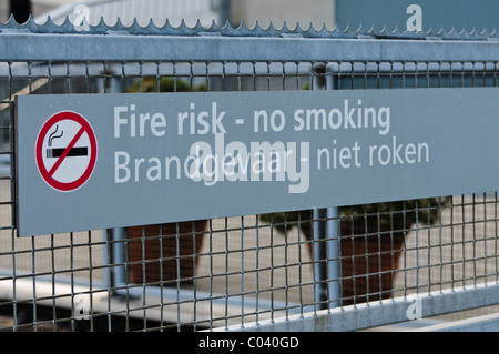 Bilingual sign in English and Dutch: Fire risk, no smoking.  Brandgevaar, niet roken Stock Photo