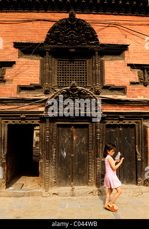 young girl walking past old building , peoples lives ( the nepalis ) ,  life in kathmandu , kathmandu street life , nepal Stock Photo