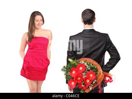 A man in black suit hiding flowers and an attractive woman Stock Photo