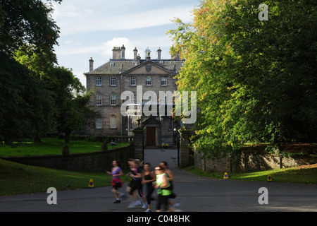 Joggers passing Pollok House run by the National Trust For Scotland in Pollok Country Park, Glasgow, Scotland, UK Stock Photo