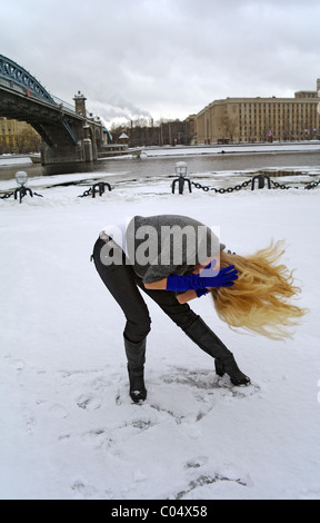 The girl in dance holds hands on a head in the winter on snow on Pushkinsky quay, Moscow, Russia Stock Photo