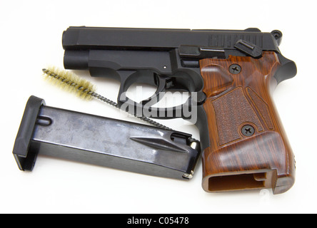 The close up of a pistol a target and cartridges is isolated on a white background Stock Photo