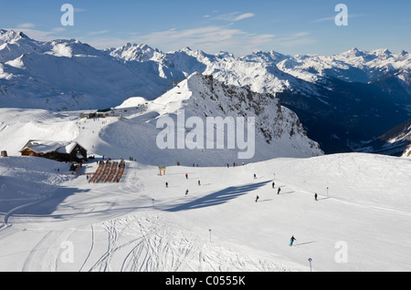 Skiers on ski slopes above Ulmer Hutte bergrestaurant in the Austrian Alps. St Anton am Arlberg, Tyrol, Austria, Europe. Stock Photo