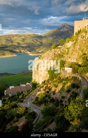 View of man-made reservoir over houses in typical / traditional Spanish white village of Zahara: Dusk / sunset / sun set. Spain. Stock Photo