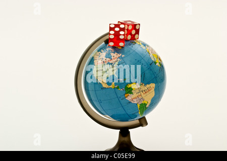 Pair of dice on top of a globe Stock Photo