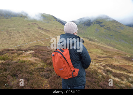 Female fell walker on a rainy day in the Lake District, near the summit of Outerside above Coledale, Cumbria Stock Photo