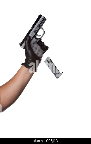 A man reloading a weapon drops the clip from a black handgun. Works great for crime or home security concepts. Stock Photo