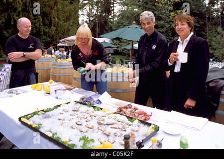 Raw Oysters served in a Half Shell on Ice at Oyster Bar at Wine & Culinary Festival, Vancouver Island, British Columbia, Canada Stock Photo