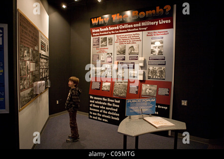 Eight year old child reading about World War II, Atomic bomb use in Hiroshima. 'Why the bomb?'  Science museum, Los Alamos, NM Stock Photo