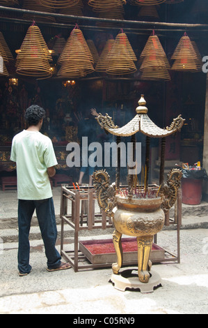 China, Hong Kong, New Territories, Tai Po area. Inside famous Man Mo Temple, hanging coils of burning incense used as offering. Stock Photo