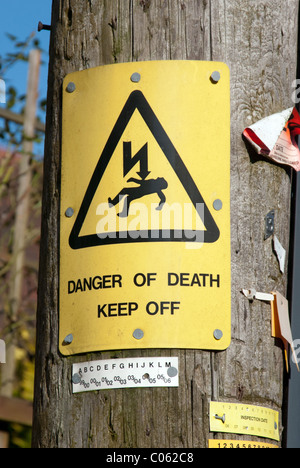 'Danger of Death Keep Off' sign on a telegraph pole in a UK country village. The sign refers to the risk from the power supply. Stock Photo