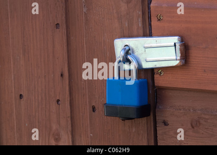 A plastic-coated padlock on a shed door.  Padlocks are useful to deter casual thieves. Stock Photo