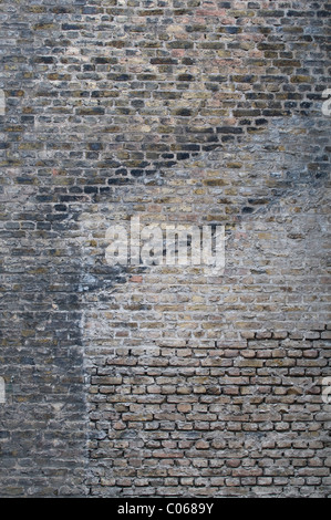 Brick wall with traces of earlier buildings, two roof ridges and plaster remains on the former building walls, background Stock Photo