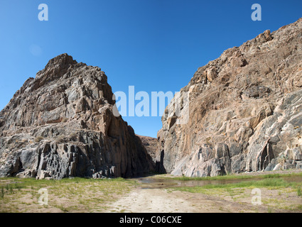 Kaokoland game reserve in Namibia, sand track going toward the Skeleton Coast Desrt with a blue sky Stock Photo