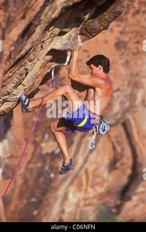 Male rock climber clinging to a cliff. Stock Photo