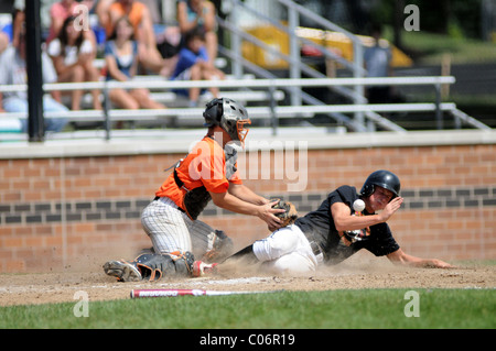 Runner slides in safely to the plate as the catcher is unable to hold on to the throw home. USA. Stock Photo