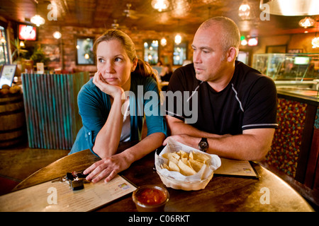 A couple in their 30's seem to be having an unhappy date at a California restaurant. MODEL RELEASE Stock Photo