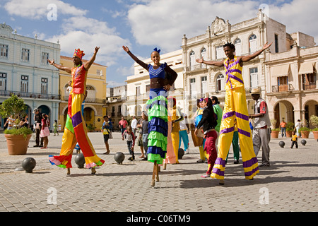 A group of street artist or performers parading on stilts walk through the streets of Havana, Cuba in bright colourful costumes Stock Photo