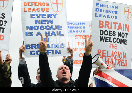 Proud EDL supporters sing England songs with there hands in the air and holding banners Stock Photo