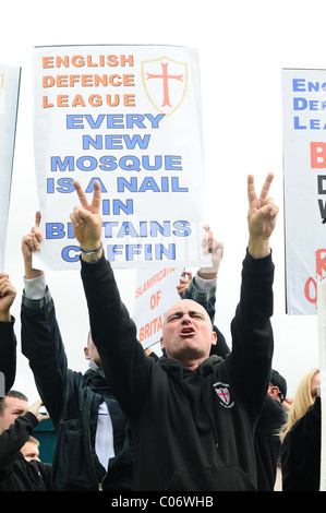 Proud EDL supporters sing England songs with there hands in the air and holding banners Stock Photo