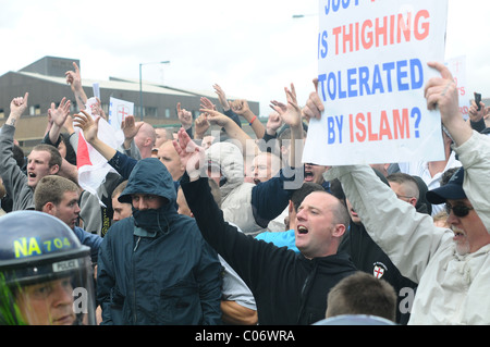 EDL supporters sing England songs at the UAF in front of the police line Stock Photo