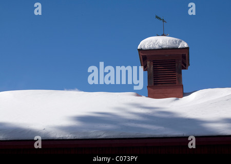 New England barn sports a weather vane on its cupola. Stock Photo