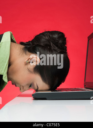 Businesswoman in front of a laptop with head down Stock Photo