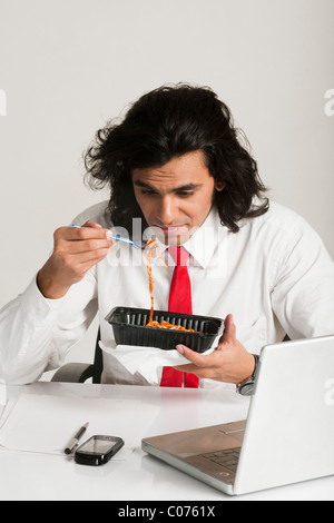 Businessman frowning at a bowl of noodles Stock Photo