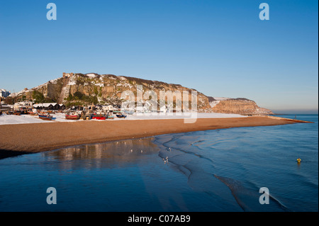 The Stade fishing beach and East Hill covered with snow on a sunny winter's day . Hastings East Sussex England UK Stock Photo