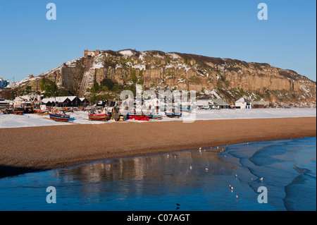 The Stade fishing beach and East Hill covered with snow on a sunny winter's day . Hastings East Sussex England UK Stock Photo