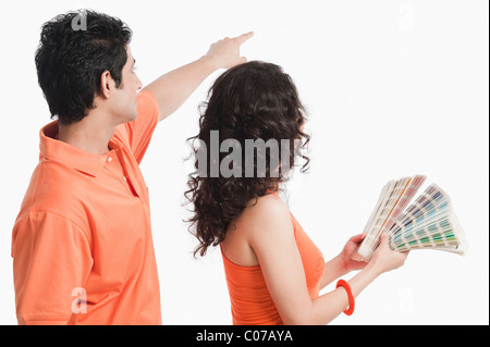 Couple choosing color from color swatches for their house Stock Photo