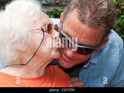 97 year old nursing home resident kissing her son-in-law Stock Photo