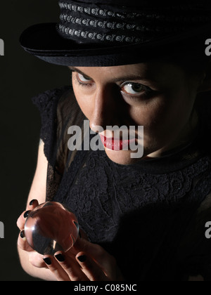 Red lipped woman with crystal ball Stock Photo