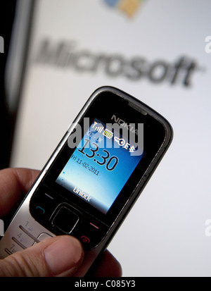 Nokia mobile phone and Microsoft logo on computer screen Stock Photo