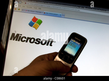 Nokia mobile phone and Microsoft logo on computer screen Stock Photo