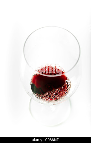A glass of Red Wine being poured from the bottle on a white background. Stock Photo