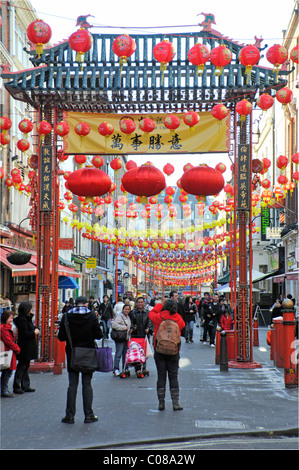 Decorations colourful lanterns & people in Chinatown gateway West End London tourism & shopping scene in Gerrard Street China Town district England UK Stock Photo