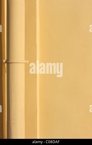Yellow pipe on the yellow wall Stock Photo