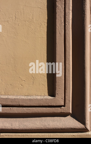 yellow plastered wall with brown decor Stock Photo