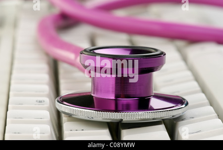 pink doctors stethoscope on white computer keyboard Stock Photo