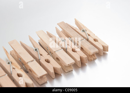 Wooden clothes pegs on silver reflective background. Stock Photo