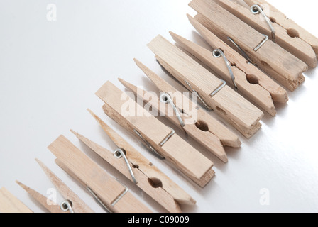 Wooden clothes pegs on silver reflective background. Stock Photo