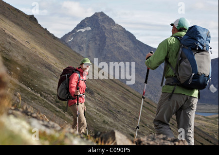 Two backpackers hiking to Ptarmigan Pass, Chugach State Park, Southcentral Alaska, Summer Stock Photo