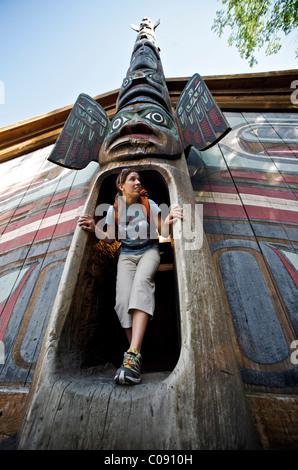 Woman explores the clan house at Totem Bight State Historical Park near Ketchikan, Southeast Alaska, Summer Stock Photo