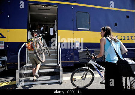 Two female bicyclists board the Alaska Railroad in Portage for a whistle stop trip to Spencer Glacier, Alaska Stock Photo