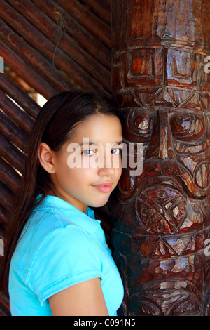 Latin mexican teen girl smile with indian wood totem Stock Photo