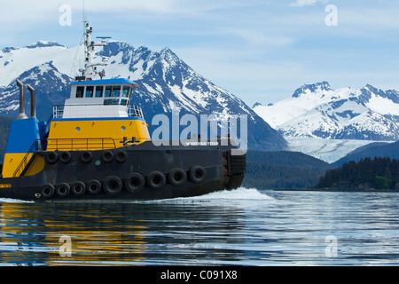 A tug pulling a barge cruises through the Inside Passage on its way south from Skagway, Alaska. Lynn Canal, Alaska Marine Lines. Stock Photo